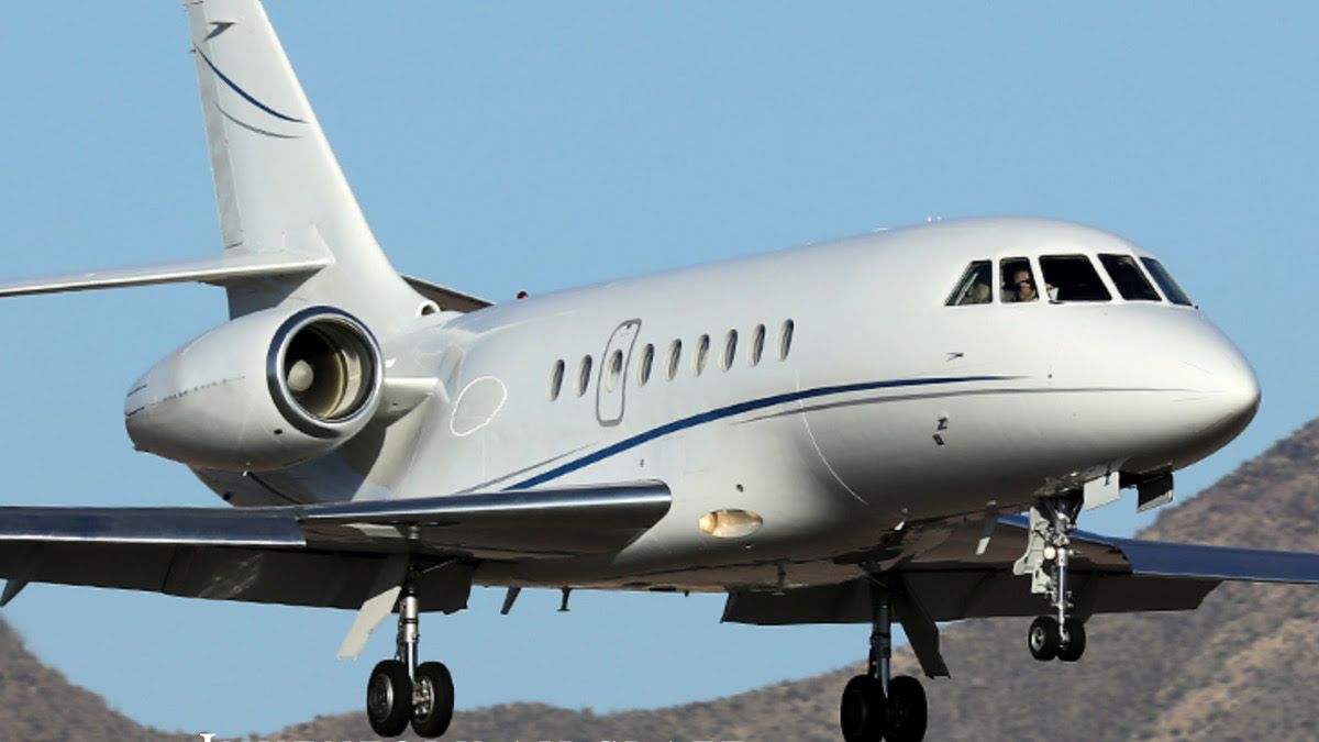 white charter airplane before blue sky and hills